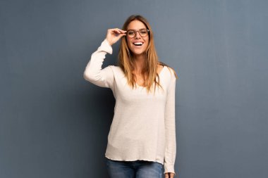 Gri arka plan ile gözlük ve sürpriz sarışın kadın