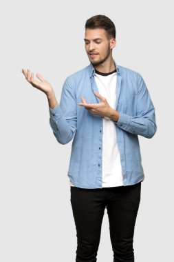 Yakışıklı adam uzanan eller gri arka plan üzerinde gelmek davet için yan