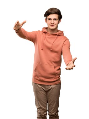 Genç adam ile sunulması ve izole beyaz arka plan üzerinde el ile gelmek davet sweatshirt