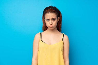 Üzgün ve depresyonda ifade ile mavi arka plan genç Kızıl saçlı kadın