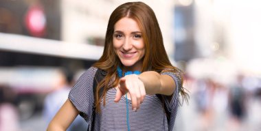 Kızıl saçlı öğrenci kadın puan parmak size şehrin kendine güvenen bir ifade ile