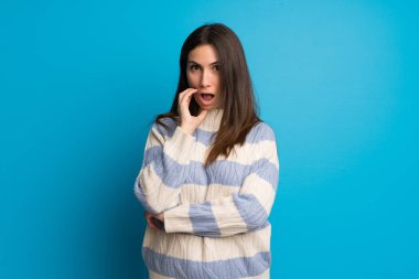 Genç kadın şaşırttı ve doğru bakarken şok mavi duvarın üzerinden