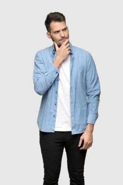 Yakışıklı adam gri arka plan üzerinde düşünme