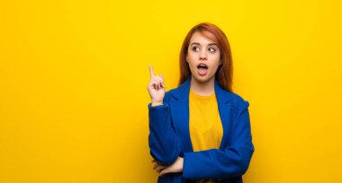 Trençkot parmak işaret bir fikir düşünce ile genç Kızıl saçlı kadın