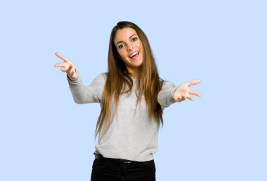 sunulması ve mavi arka plan üzerinde el ile gelmek davet genç kız