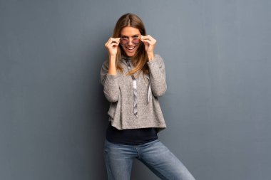 Gri arka plan ile gözlük ve sürpriz sarışın kadın