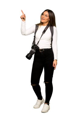 Uzağa işaret eden genç fotoğrafçı kadının tam vücut