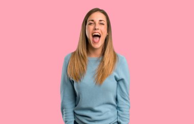 Mavi gömlek izole pembe arka plan açık ağız ile ön bağıran sarışın kadınla