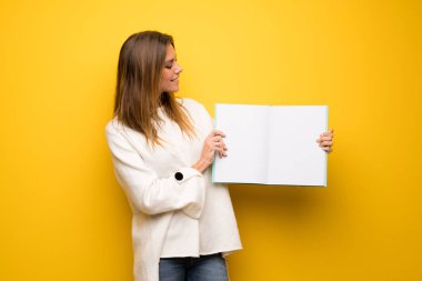 Sarışın kadın için bir afiş tutarak sarı duvarın üzerinden bir kavram Ekle