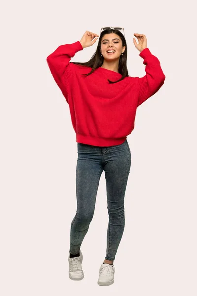 メガネと分離背景微笑む赤いセーターとティーンエイ ジャーの女の子のフルレングス ショット — ストック写真