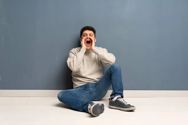Mladý Muž Sedí Podlaze Křiku Oznamuje Něco — Stock fotografie