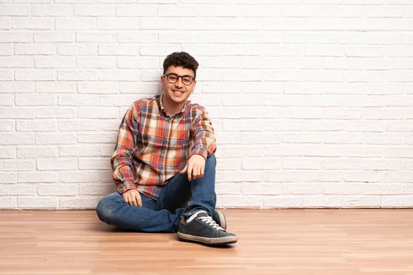 Junger Mann Sitzt Mit Brille Auf Dem Boden Und Ist — Stockfoto