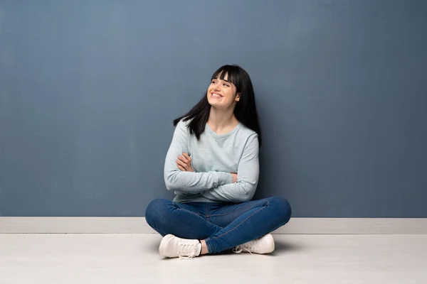 Frau Sitzt Glücklich Und Lächelnd Auf Dem Boden — Stockfoto