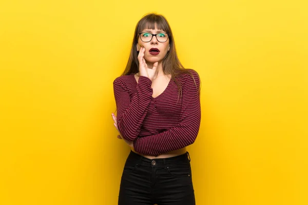 Mujer Con Gafas Sobre Pared Amarilla Sorprendida Sorprendida Mientras Mira — Foto de Stock