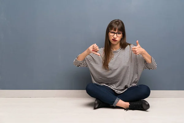 Frau Mit Brille Sitzt Auf Dem Boden Und Zeigt Daumen — Stockfoto