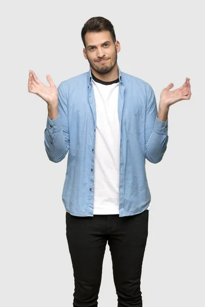 Handsome Man Having Doubts While Raising Hands Grey Background — Stock Photo, Image