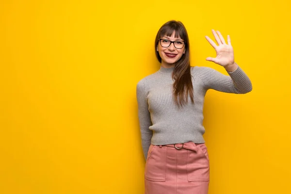 Žena Brýlemi Nad Žluté Stěny Pěti Prsty — Stock fotografie