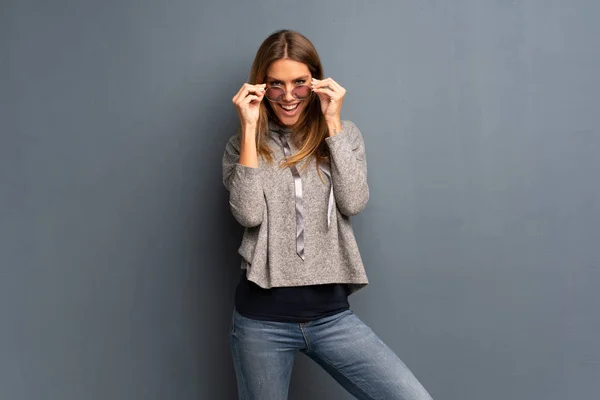 Mujer Rubia Sobre Fondo Gris Con Gafas Sorprendida — Foto de Stock
