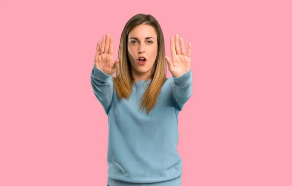 金发碧眼的女人与蓝色衬衫做停止手势失望与意见在孤立的粉红色背景 — 图库照片