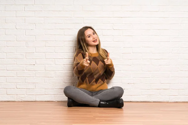 Tiener Meisje Zitten Vloer Wijzend Naar Voorkant Glimlachend — Stockfoto