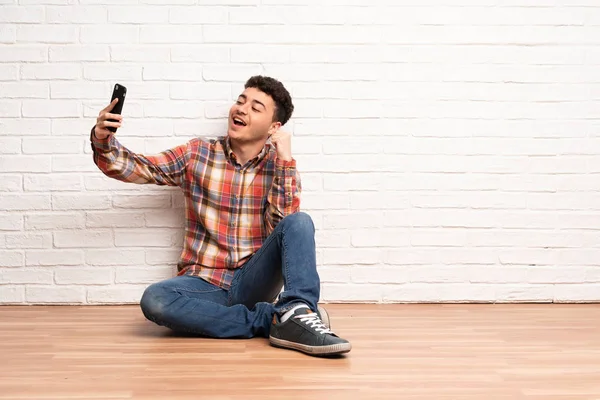 Νεαρός Άνδρας Κάθεται Στο Πάτωμα Κάνοντας Μια Selfie — Φωτογραφία Αρχείου