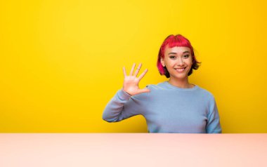 Beş parmak ile sayma pembe saçlı genç kadın