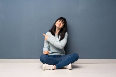 Ürün sunmak için tarafına işaret katta oturan kadın