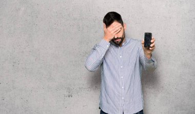 Kırık smartphone dokulu duvar'ın üstüne holding ile gömlek ile zarif adam sorunlu
