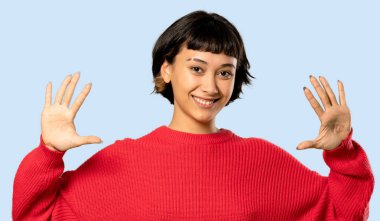 Kısa saçlı kız kırmızı kazaklı on parmak izole mavi arka plan ile sayma