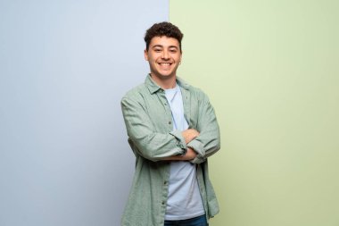 Mavi ve yeşil arka plan ön konumda geçti silah tutan genç adam