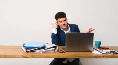 Parmak kafasına koyarak delilik jesti yapmak bir ofiste iş adamı
