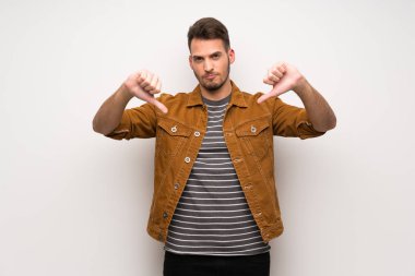 Beyaz duvar gösteren başparmak dowg negatif ifade ile yakışıklı adam