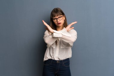 Hiçbir hareketi yapma mavi duvarın üzerinden gözlüklü kadın