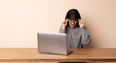 Onu laptop ile gözlük ve sürpriz ile çalışan genç kadın
