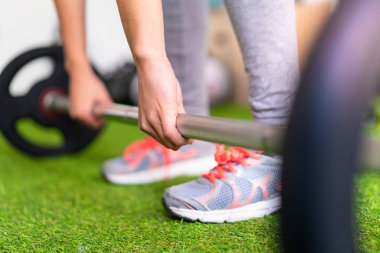 Genç kadın halter yapma bir spor salonunda spor
