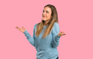 El ve izole pembe arka plan omuzlarında yetiştirme süre şüpheleri mavi gömlek ile sarışın kadın