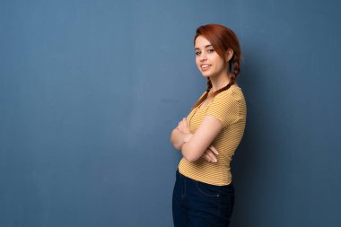 Mavi renkli yatay konumda gülümseyen süre geçti silah tutan genç Kızıl saçlı kadın