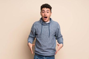 Sürpriz yüz ifadesi ile izole duvarın üzerinden genç adam