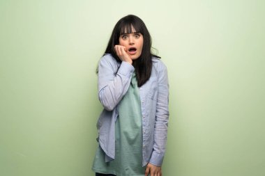 Genç kadın şaşırttı ve doğru bakarken şok yeşil duvar yüzünden