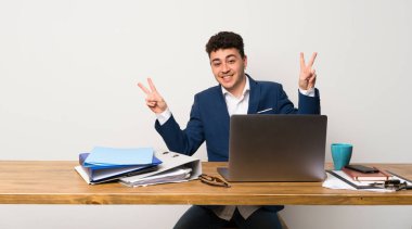 Her iki el ile zafer işaret gösteren bir ofiste iş adamı