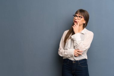 Mavi duvar ararken şüpheleri üzerinden gözlüklü kadın