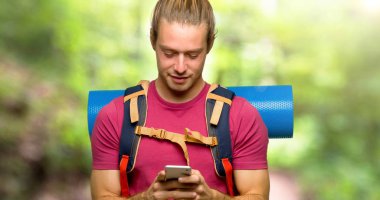 Dağın içinde Mobil ileti gönderme dağ backpacker adamla uzun yürüyüşe çıkan kimse