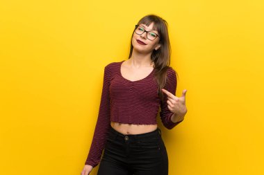 Kibirli ve kendini beğenmiş sarı duvarın üzerinden gözlüklü kadın