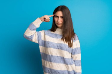 Mavi duvar parmak kafasına koyarak delilik jest yapma genç kadın