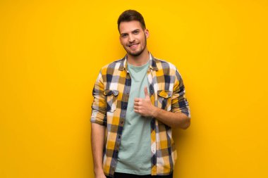 Jest Yaşasın vererek ve gülümseyen sarı duvarın üzerinden yakışıklı adam