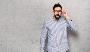 Gömlek ile gözlük ve dokulu duvarın üzerinden sürpriz ile zarif adam