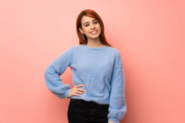 Kalça, silah ile poz ve gülümseyen pembe genç Kızıl saçlı kadın