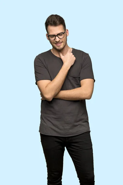 Hombre Con Camisa Negra Con Gafas Sonriendo Sobre Fondo Azul — Foto de Stock