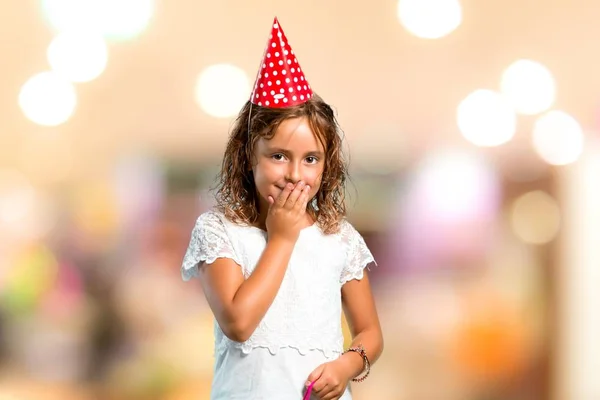 Bambina ad una festa di compleanno con una borsa regalo che ride su uno sfondo sfocato — Foto Stock