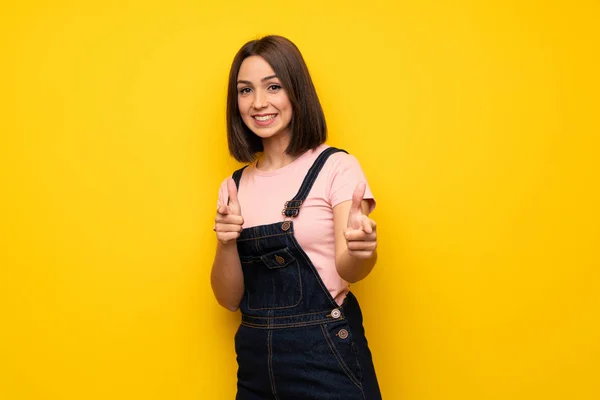 Genç Kadın Önüne Işaret Gülümseyen Sarı Duvarın Üzerinden — Stok fotoğraf